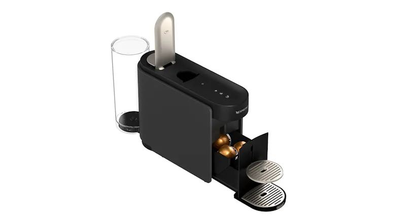 Top‑open view of Nespresso machine with capsules showing metallic lever and tray Top‑open view of Nespresso machine with capsules showing metallic lever and tray
