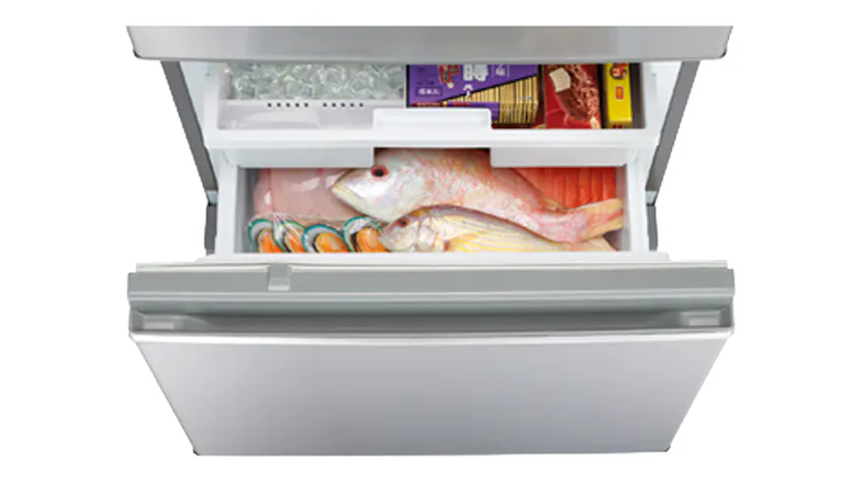 Mitsubishi freezer door open, displaying organised food and ice storage Mitsubishi freezer door open, displaying organised food and ice storage