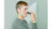 A person trimming facial hair above the upper lip with a compact Panasonic travel shaver A person trimming facial hair above the upper lip with a compact Panasonic travel shaver