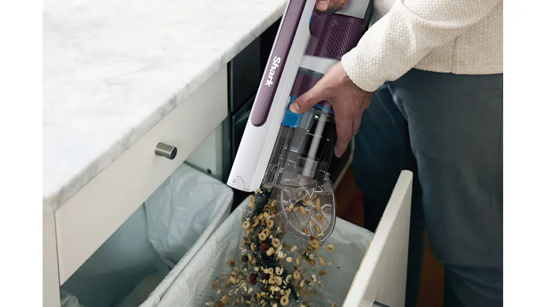 Hand removing the vacuum dust bin showing easy emptying mechanism Hand removing the vacuum dust bin showing easy emptying mechanism