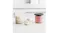 Dessert tub filled with a pink frozen mixture, placed on a kitchen countertop beside ingredients Dessert tub filled with a pink frozen mixture, placed on a kitchen countertop beside ingredients