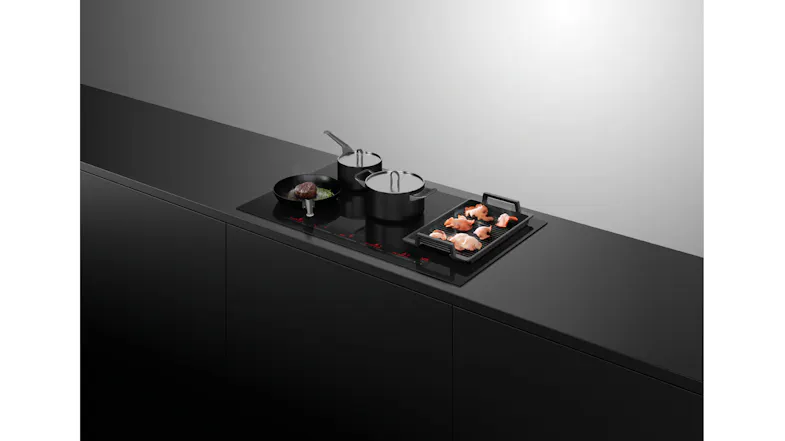 Angled kitchen view of the induction cooktop with cookware in use Angled kitchen view of the induction cooktop with cookware in use
