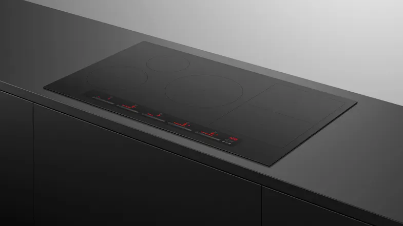 Perspective view of the Fisher & Paykel Series 7 induction cooktop installed flush within a dark countertop Perspective view of the Fisher & Paykel Series 7 induction cooktop installed flush within a dark countertop