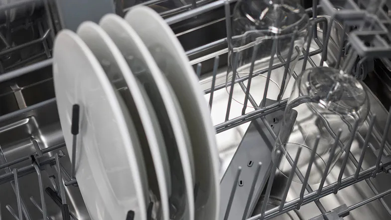 Interior view of the dishwasher loaded with plates and glassware Interior view of the dishwasher loaded with plates and glassware