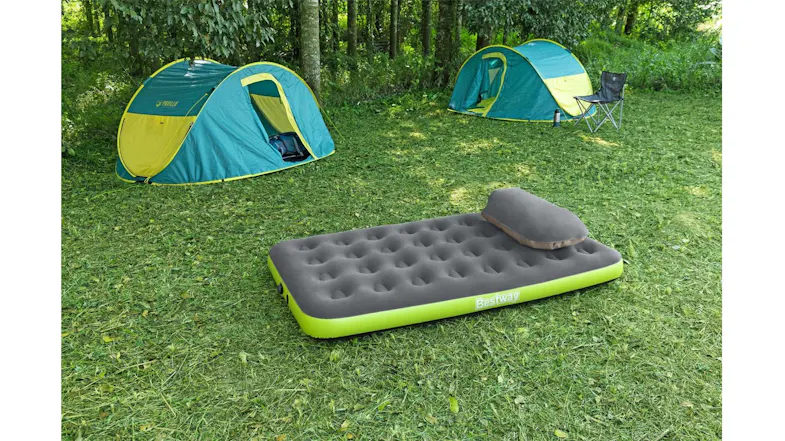 Lightweight inflatable air bed with cushioned top and pillow positioned on a grassy campsite Lightweight inflatable air bed with cushioned top and pillow positioned on a grassy campsite