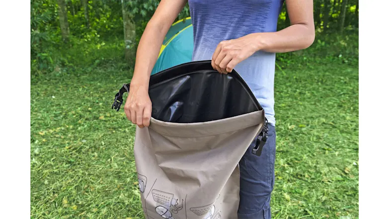 A camper holding a waterproof storage bag for a Bestway air mattress, shown at an outdoor setting A camper holding a waterproof storage bag for a Bestway air mattress, shown at an outdoor setting
