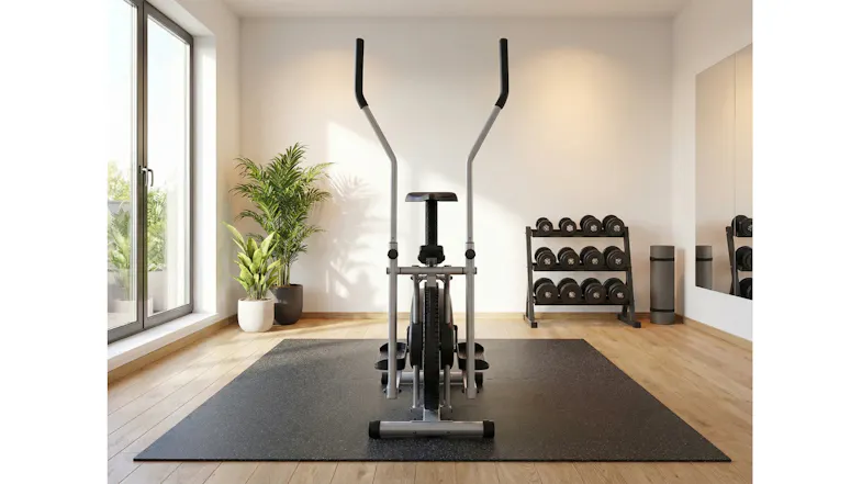Air resistance elliptical bike in a modern home gym with dumbbells, mat, and natural light Air resistance elliptical bike in a modern home gym with dumbbells, mat, and natural light