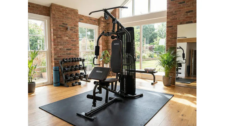 Home fitness station with lat pulldown, chest press, and preacher curl pad in a sunlit gym Home fitness station with lat pulldown, chest press, and preacher curl pad in a sunlit gym
