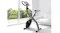 A stationary folding exercise bike positioned inside a brightly lit, modern living room space A stationary folding exercise bike positioned inside a brightly lit, modern living room space