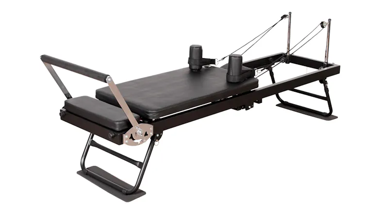 A full side view of the PROTRAIN Reformer Pilates Device with Headrest A full side view of the PROTRAIN Reformer Pilates Device with Headrest