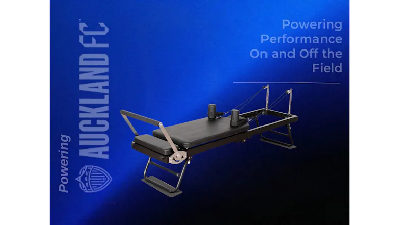 A black pilates reformer set against a blue gradient graphic featuring Auckland FC branding A black pilates reformer set against a blue gradient graphic featuring Auckland FC branding