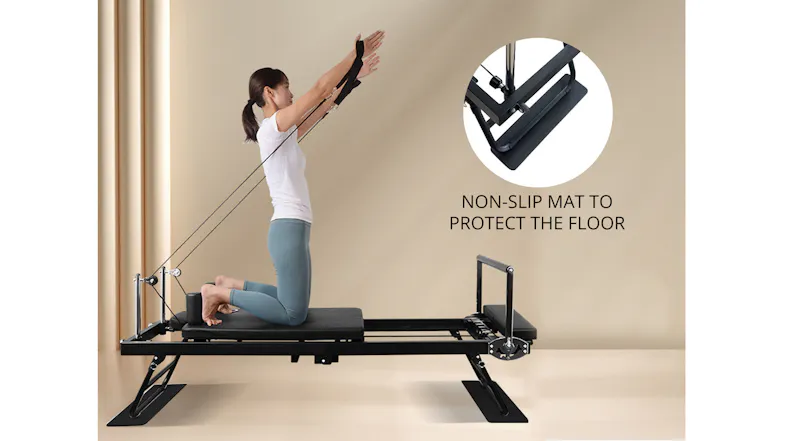 Woman kneeling on a Pilates reformer doing arm extensions, with an inset highlighting the non-slip floor mat Woman kneeling on a Pilates reformer doing arm extensions, with an inset highlighting the non-slip floor mat