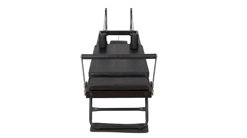 A front view of a black folding Pilates reformer machine highlighting the headrest, carriage, and padded footbar A front view of a black folding Pilates reformer machine highlighting the headrest, carriage, and padded footbar