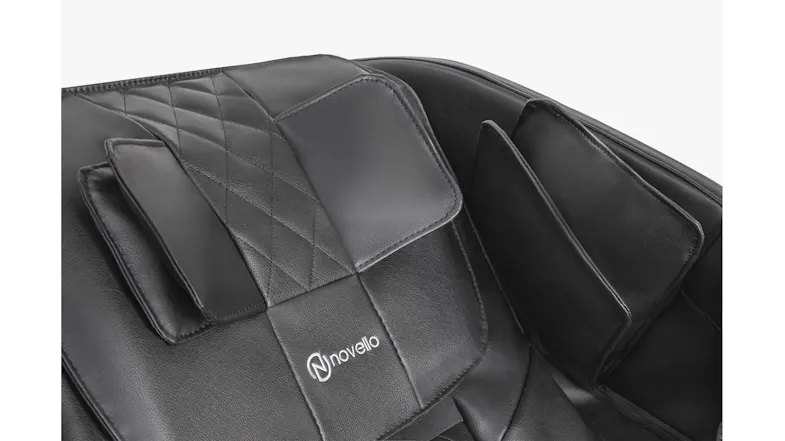 Close-up view of Novello massage chair headrest pillow with embroidered logo and shoulder airbag massagers in black Close-up view of Novello massage chair headrest pillow with embroidered logo and shoulder airbag massagers in black