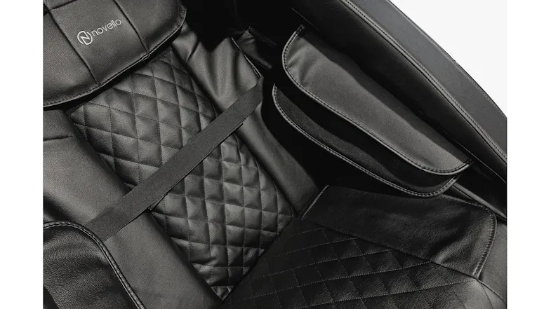 Detailed view of Novello massage chair interior showcasing diamond-quilted back cushion and padded arm massage slots Detailed view of Novello massage chair interior showcasing diamond-quilted back cushion and padded arm massage slots