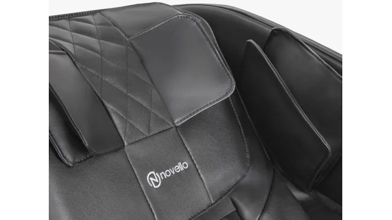 Close-up view of padded headrest pillow and shoulder airbag panels on black leatherette Novello brand massage chair Close-up view of padded headrest pillow and shoulder airbag panels on black leatherette Novello brand massage chair