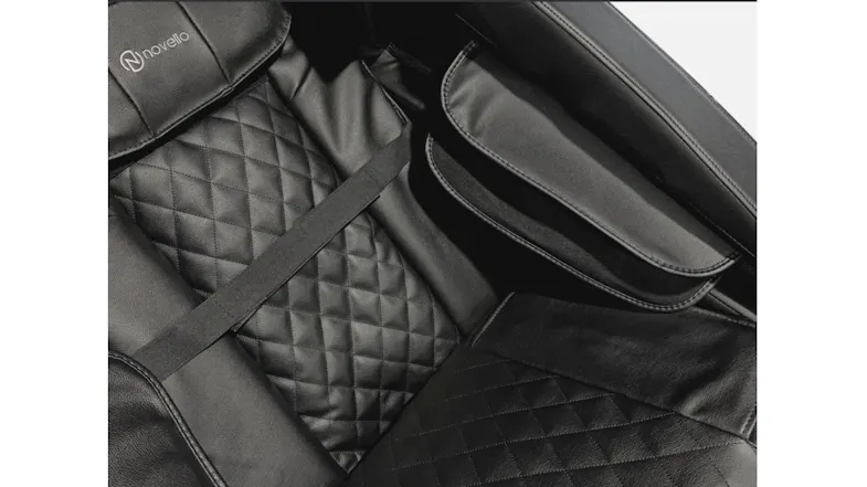 Detailed view of interior massage seat featuring diamond-quilted back cushion and side armrest compression massage slot Detailed view of interior massage seat featuring diamond-quilted back cushion and side armrest compression massage slot