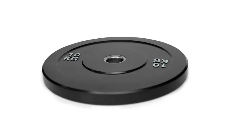 An angled view showing a single black bumper weight plate resting flat on a white surface An angled view showing a single black bumper weight plate resting flat on a white surface