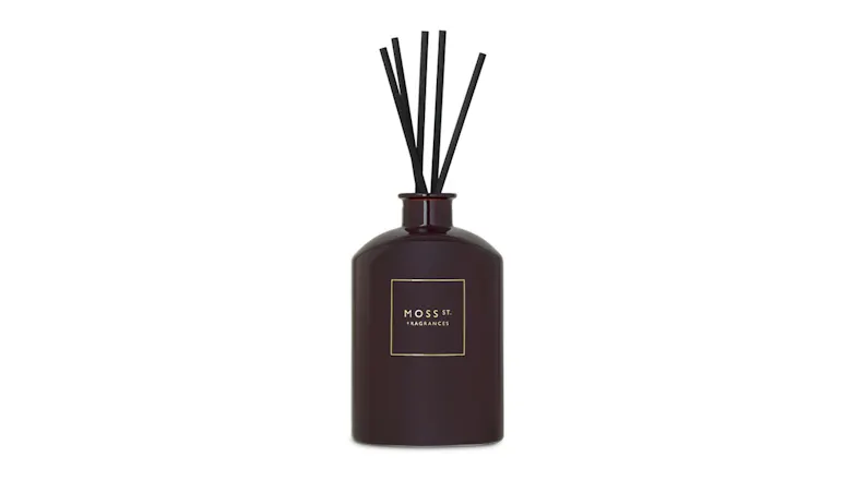 Dark glass bottle of Moss St. Vintage Leather & Cedarwood reed diffuser with five black reeds Dark glass bottle of Moss St. Vintage Leather & Cedarwood reed diffuser with five black reeds