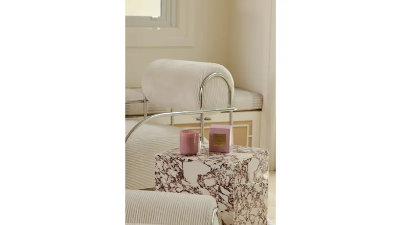 Interior setting featuring a pink candle and box on a marble side table Interior setting featuring a pink candle and box on a marble side table