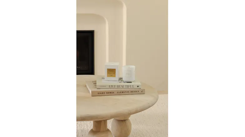 Minimalist room showcasing a candle and box on stacked books Minimalist room showcasing a candle and box on stacked books