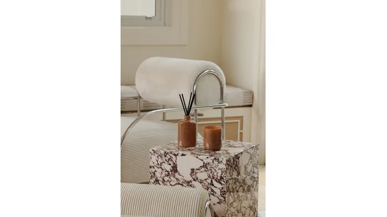 Modern interior showcasing a reed diffuser and candle on side table Modern interior showcasing a reed diffuser and candle on side table