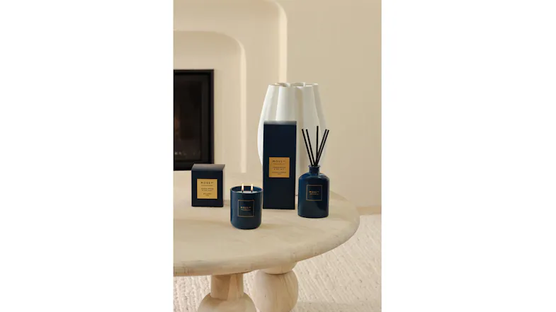 Warm setting highlighting a reed diffuser and candle on coffee table Warm setting highlighting a reed diffuser and candle on coffee table