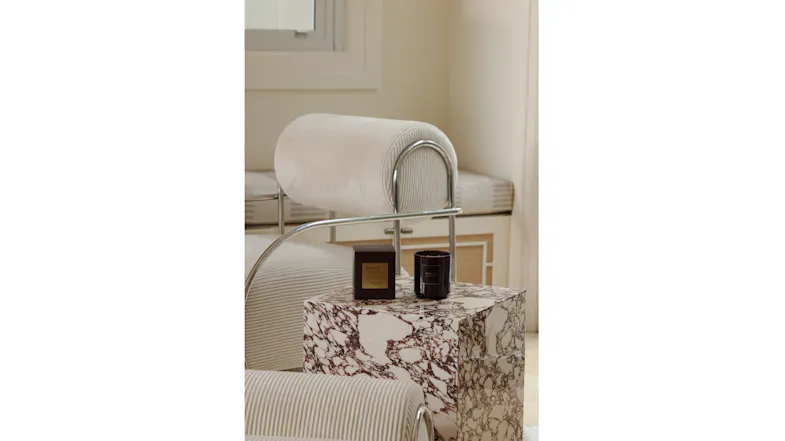 Interior view featuring a dark plum candle and box on marble side table Interior view featuring a dark plum candle and box on marble side table