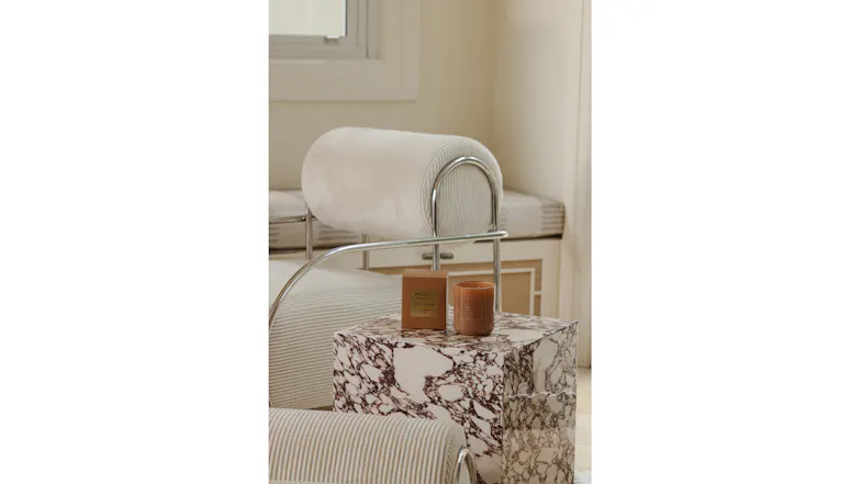 Living space featuring a brown candle and packaging on a marble table Living space featuring a brown candle and packaging on a marble table