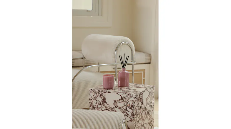Modern room highlighting a candle and reed diffuser on a marble table Modern room highlighting a candle and reed diffuser on a marble table
