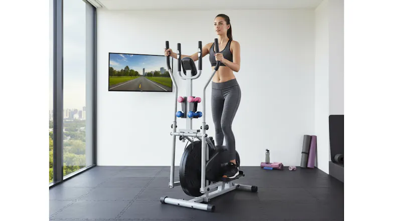 Person exercising on a ProTrain Sports elliptical trainer with built-in dumbbells in a modern home gym Person exercising on a ProTrain Sports elliptical trainer with built-in dumbbells in a modern home gym