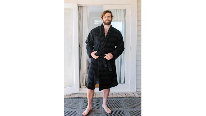 Person wearing a dark plaid Baksana Aiden Bath Robe, standing barefoot on a porch in front of open glass doors Person wearing a dark plaid Baksana Aiden Bath Robe, standing barefoot on a porch in front of open glass doors