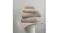 A stack of natural towels displayed on a matching bath mat atop a white pedestal A stack of natural towels displayed on a matching bath mat atop a white pedestal