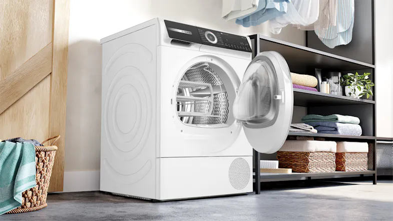 Laundry room view showcasing an open dryer next to storage shelves Laundry room view showcasing an open dryer next to storage shelves