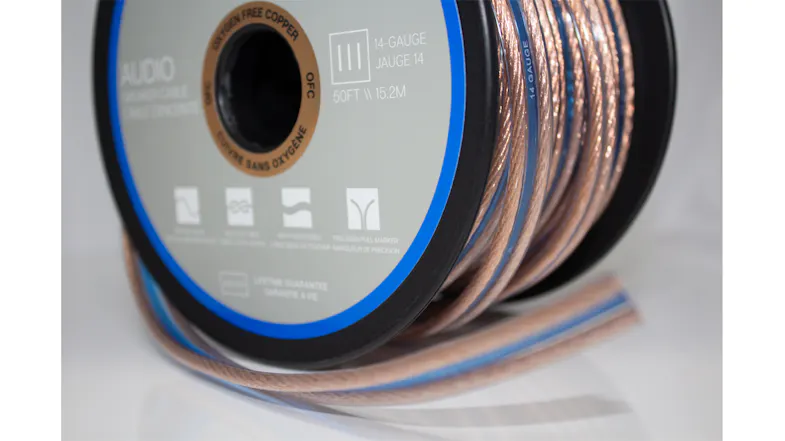 Close-up angled view of the speaker cable spool with visible copper wire and branded reel label Close-up angled view of the speaker cable spool with visible copper wire and branded reel label