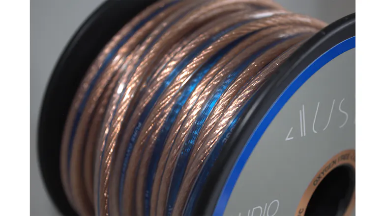 Macro close-up of the speaker cable wrapped around the spool, showcasing the copper conductors Macro close-up of the speaker cable wrapped around the spool, showcasing the copper conductors