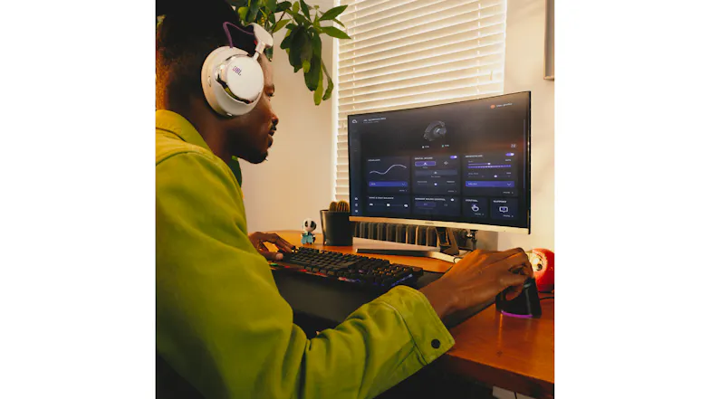 A view of a man working on his desktop computer while wearing the Quantum 950 headset A view of a man working on his desktop computer while wearing the Quantum 950 headset