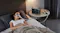 Anker SOLIX portable power station powering a bedside CPAP machine while a person rests in bed Anker SOLIX portable power station powering a bedside CPAP machine while a person rests in bed