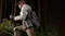 A hiker carrying a portable power station with a shoulder strap while trekking through a forest trail A hiker carrying a portable power station with a shoulder strap while trekking through a forest trail