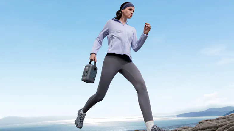 An outdoor enthusiast carrying a compact power station along a scenic shoreline for mobile power access An outdoor enthusiast carrying a compact power station along a scenic shoreline for mobile power access