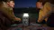 Campers using a portable power station with a built-in lantern for off-grid power after dark Campers using a portable power station with a built-in lantern for off-grid power after dark