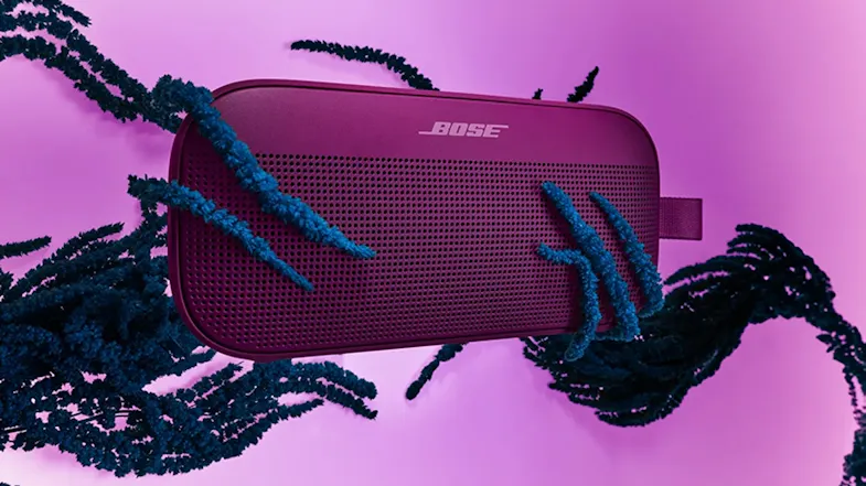 Graphic showcasing a floating Bose speaker with textured abstract tendrils behind Graphic showcasing a floating Bose speaker with textured abstract tendrils behind