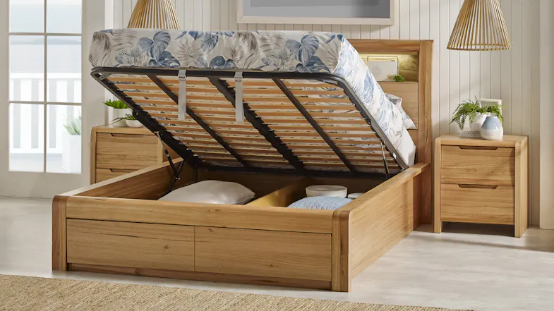 Front view of a wooden bed featuring a lift-up base with foot drawers Front view of a wooden bed featuring a lift-up base with foot drawers