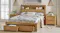 Front view of a queen-sized bed frame with one bottom drawer opened Front view of a queen-sized bed frame with one bottom drawer opened