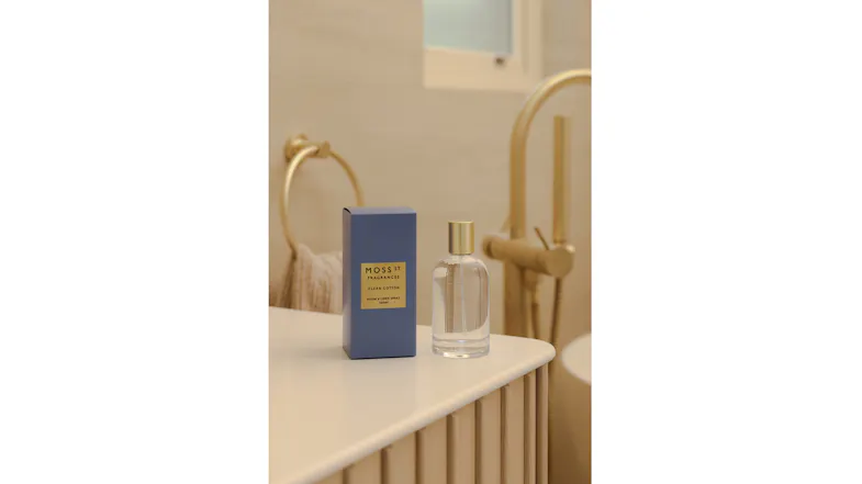 The room fragrance is displayed in a warmly-lit modern bathroom The room fragrance is displayed in a warmly-lit modern bathroom