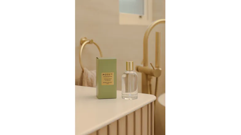 The room fragrance is displayed in a warmly-lit modern bathroom The room fragrance is displayed in a warmly-lit modern bathroom
