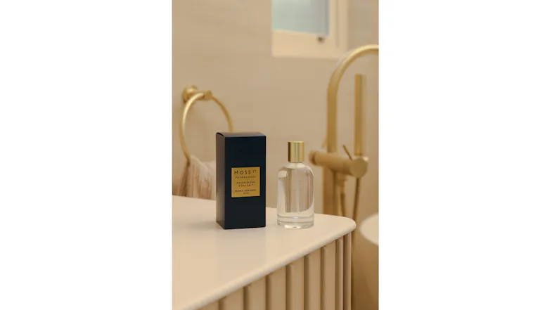 The room fragrance is displayed in a warmly-lit modern bathroom The room fragrance is displayed in a warmly-lit modern bathroom