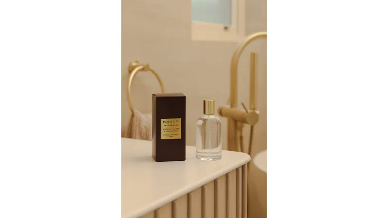 The room fragrance is displayed in a warmly-lit modern bathroom The room fragrance is displayed in a warmly-lit modern bathroom