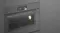 An angled side view of the oven integrated into a sleek grey wall An angled side view of the oven integrated into a sleek grey wall