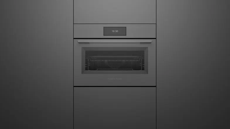 A front view of the oven integrated into a grey wall A front view of the oven integrated into a grey wall